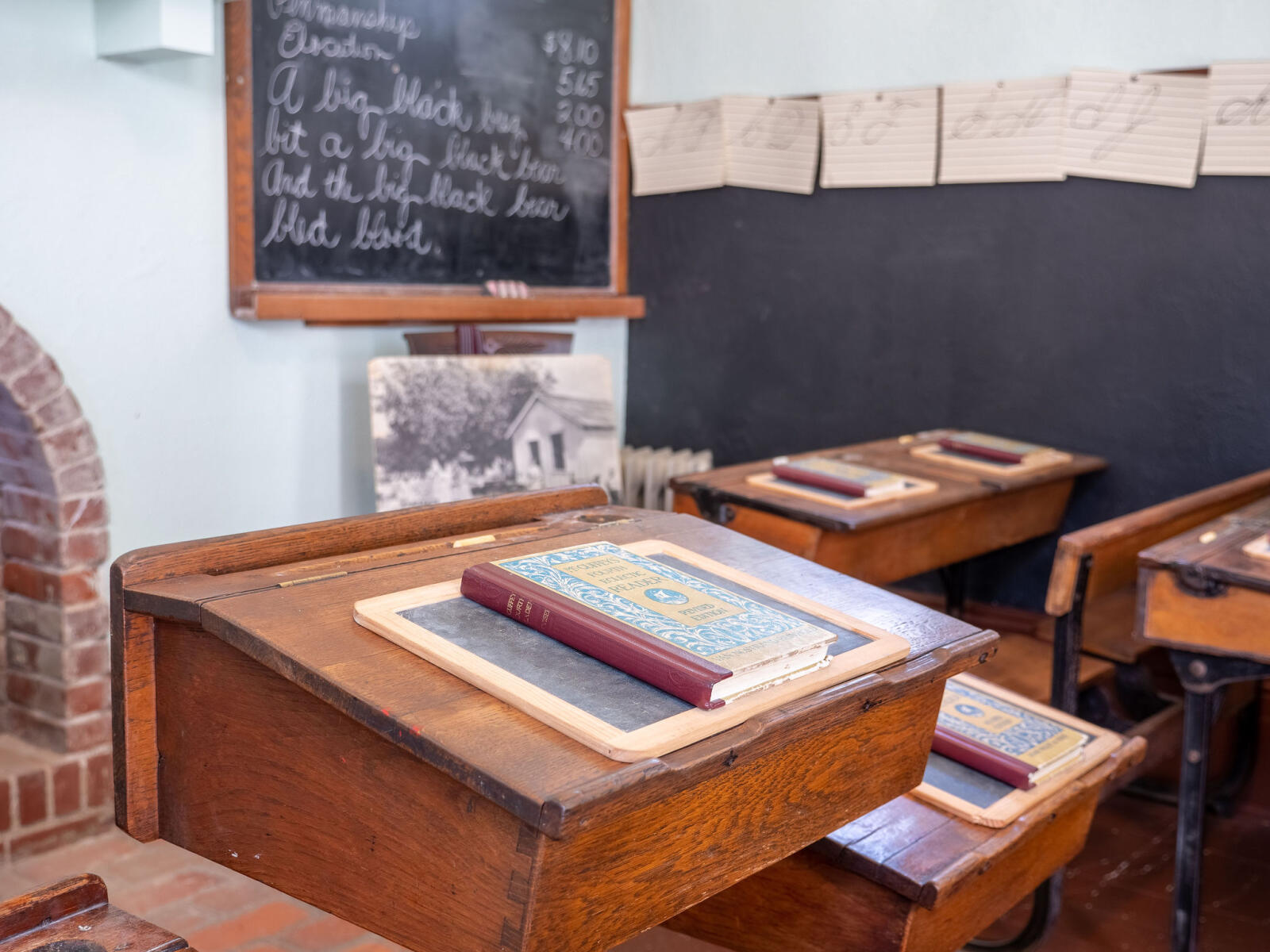 Wooden desktop with book and slate in Schoolhouse