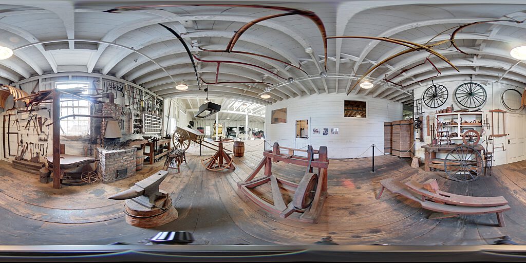 Panoramic view of blacksmith area with tools and benches.