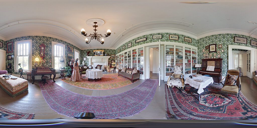 Panoramic view of Family Room with sofa, steer horn chair, mannequin in period attire, and table
