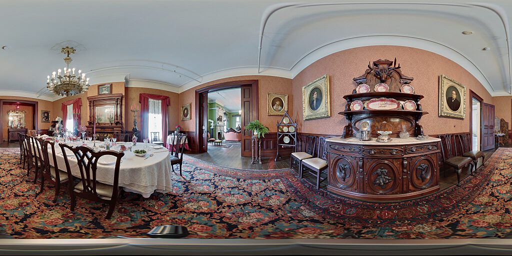 Panoramic view of the Banning dining room showing the table, chairs and wooden Victorian Era sideboard