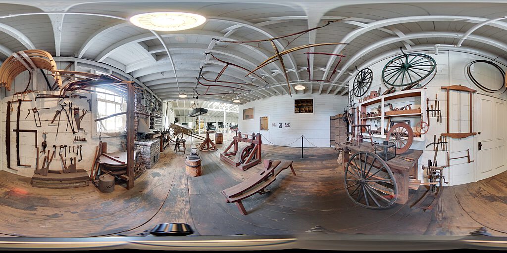 Panoramic view of blacksmith area with tools and benches.