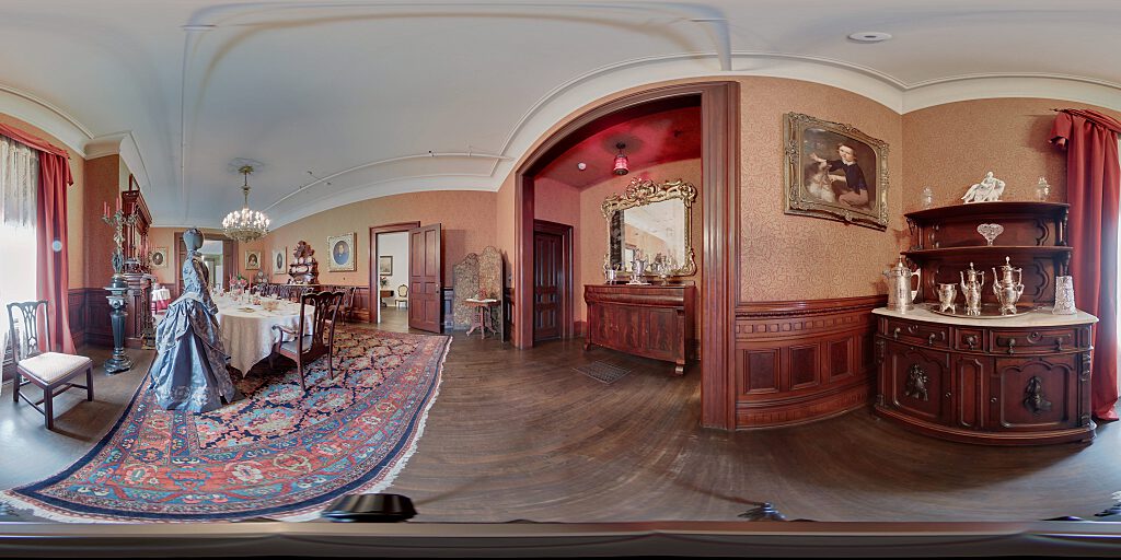 Panoramic view of Dining Room with table, sideboard, and female mannequin dressed in period attire