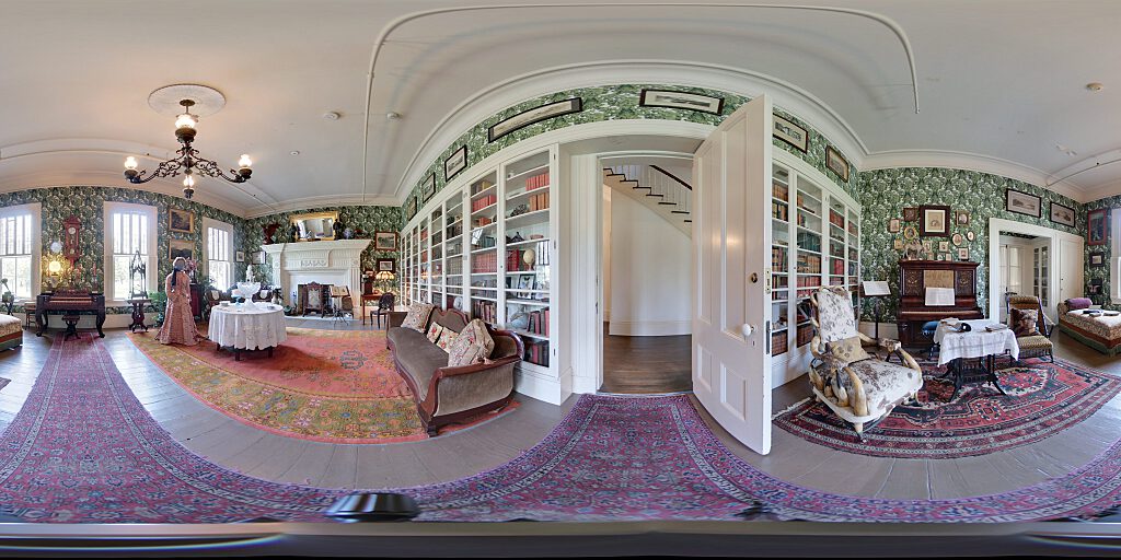 Panoramic view of Family Room with sofa, steer horn chair, mannequin in period attire, and table