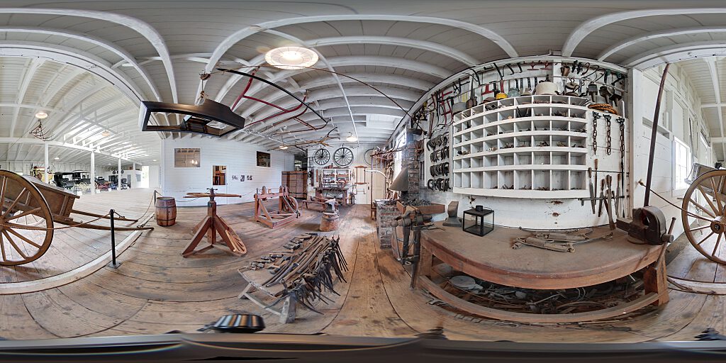 Panoramic view of blacksmith area with tools and benches.