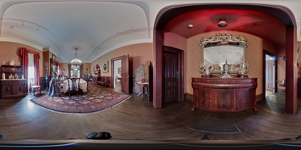 Panoramic view of Dining Room with table, sideboard, and female mannequin dressed in period attire