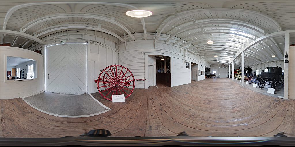 Panoramic view of Barn interior with fire cart and carriages.