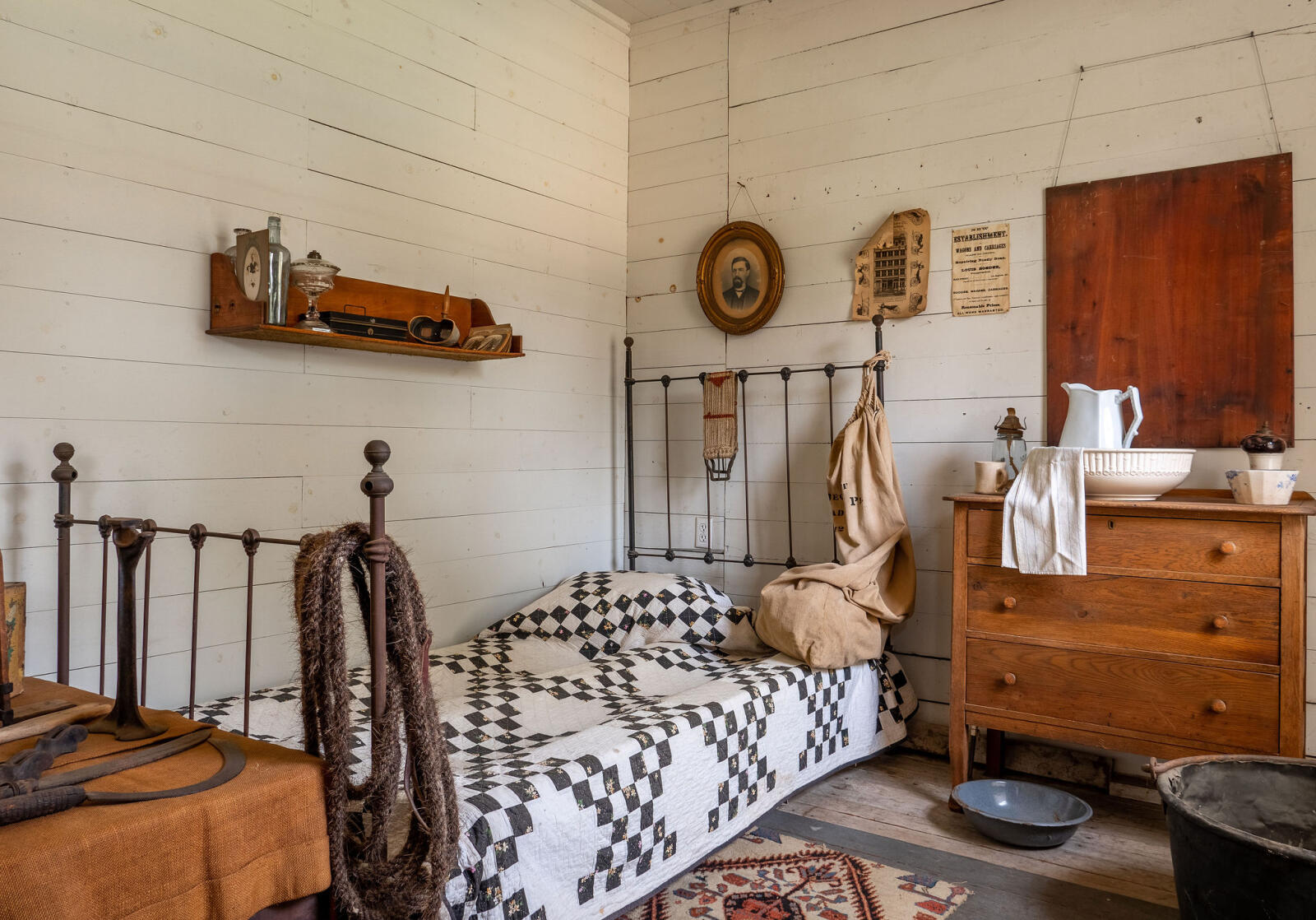 Stage coach hand's room with small bed and chest of drawers