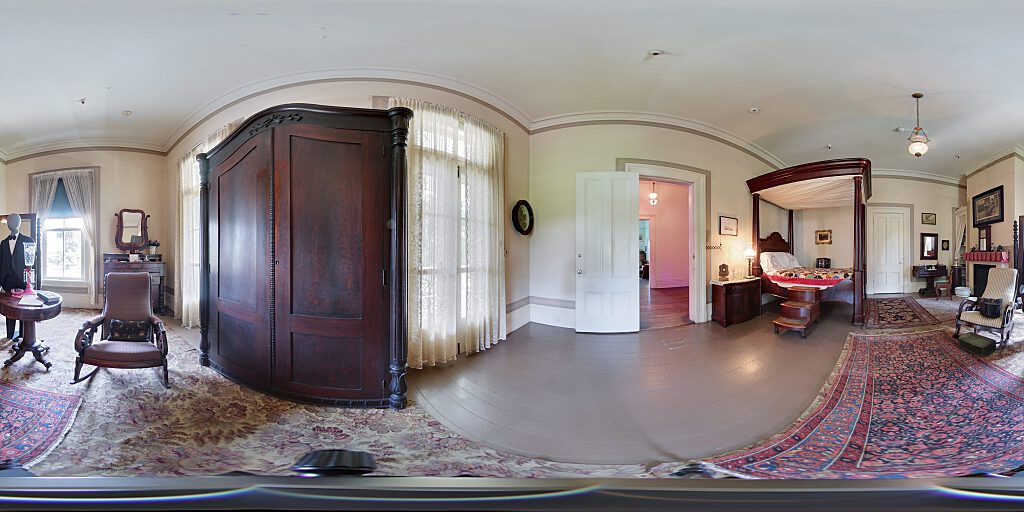Panoramic view of entrance to Master Bedroom with four-poster canopy bed and steps with armoire.