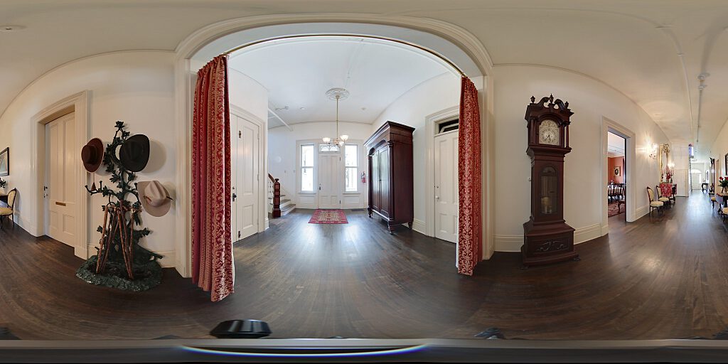Panoramic view of entrance hallway with  hat rack and grandfather clock.